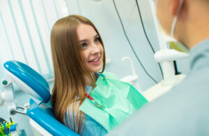 woman in a dental chair, asking about cosmetic dental in Irvine