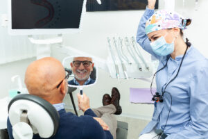 man smiling in mirror, happy with dental implants