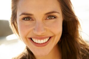 young woman smiling on beach, perfect smile, dental veneers