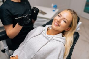 young woman smiling calmly in a dental chair, sedation dental