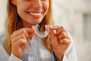 closeup of a young woman holding her clear aligners
