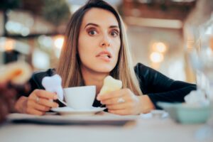 woman in coffee shop worried about yellowing teeth